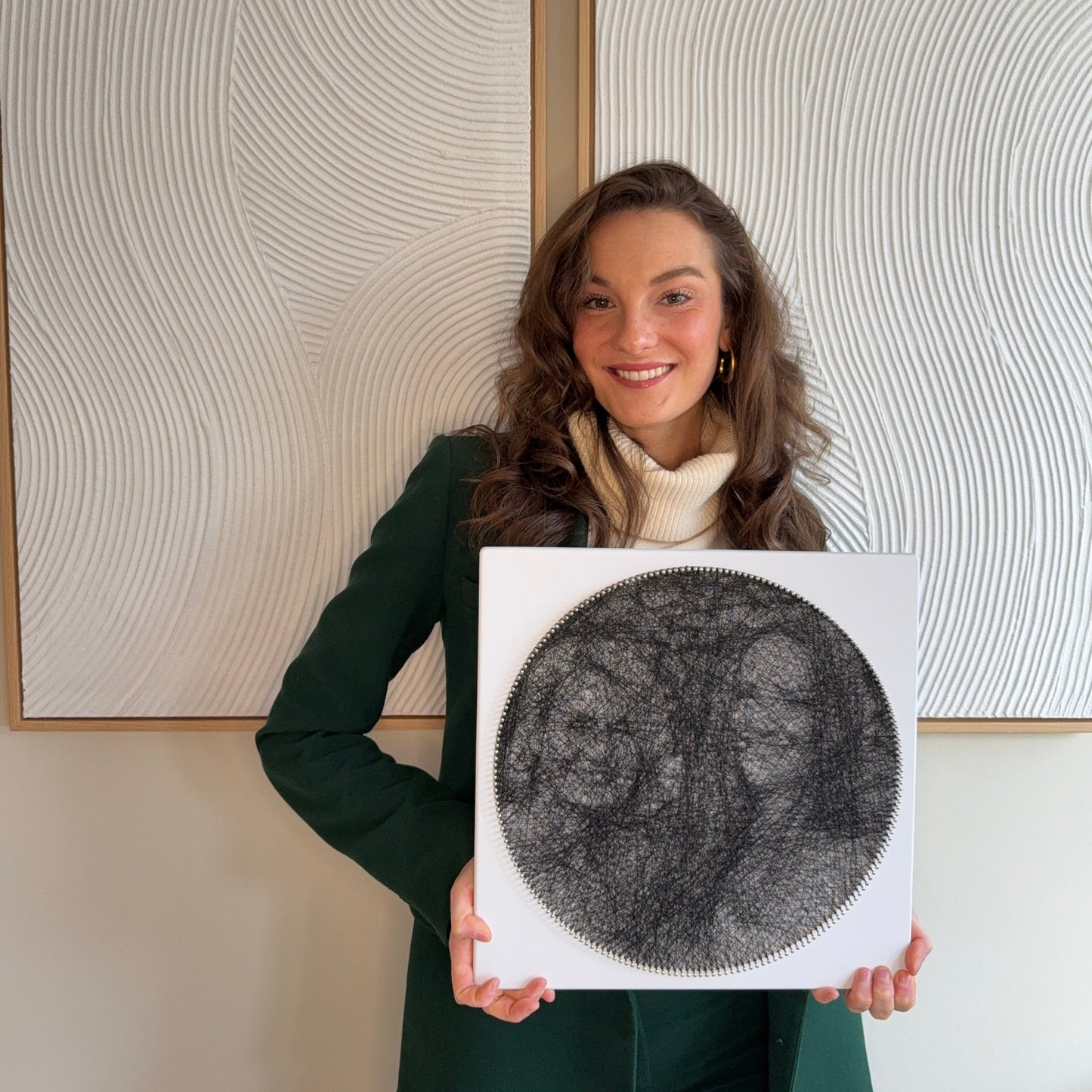 Persoon die een afgewerkte string art kunstwerk vasthoudt, gemaakt met de Studio Sarte kit.